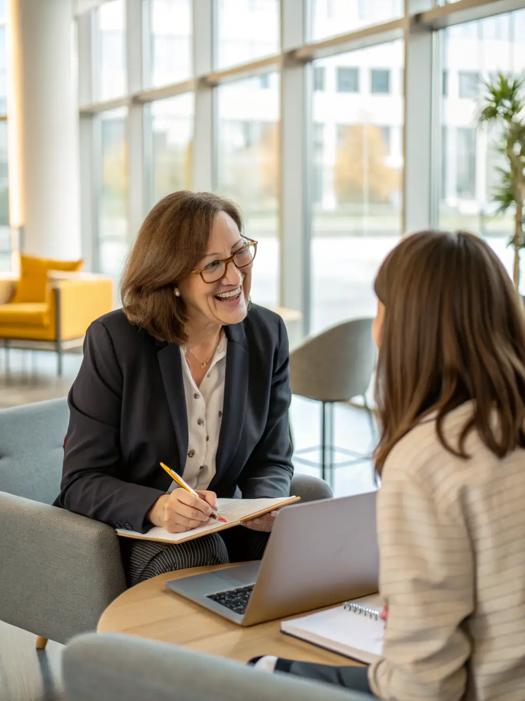 A business coach sitting across from a client in a relaxed setting, engaging in a deep conversation about career goals and personal development strategies.